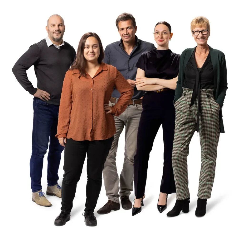 Vijf mensen poseren voor de camera tegen een witte achtergrond.